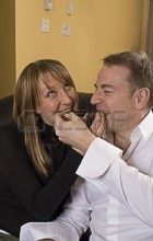 743582-portrait-of-couple-on-couch-eating-chocolate