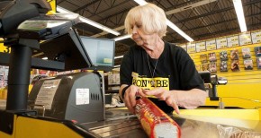 An elderly female employee working at the checkout counter in Jesse & Kelly's No Frills supermarket store Ontario, Canada. Image shot 05/2012. Exact date unknown.